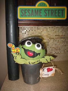 the sesame street sign is next to a trash can with a paper cut out of it