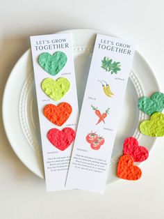 two bookmarks with hearts on them sitting on a plate