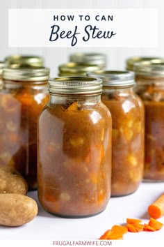 several jars filled with food sitting on top of a white table next to carrots