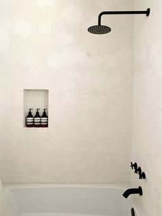 a white bath tub sitting next to a shower head