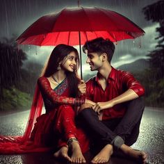 a couple sitting under an umbrella in the rain