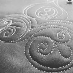 closeup of the stitching on an embroidered tablecloth with circles and swirls