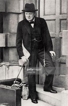 an old photo of a man in a suit and hat standing on steps with luggage