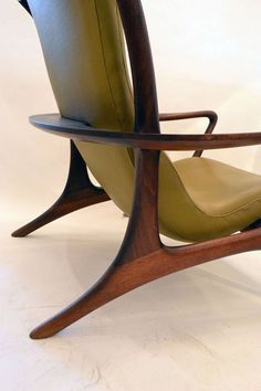 a wooden chair with green leather upholstered seat