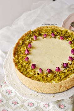 a cake with flowers on it sitting on top of a white platter next to a plate