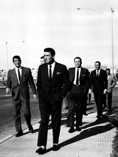 black and white photograph of men in suits walking down the street