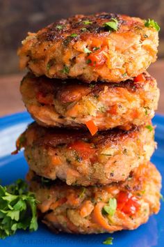 three crab cakes stacked on top of each other with broccoli in the background