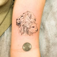 a small lion and lamb tattoo on the right arm, next to a quarter penny