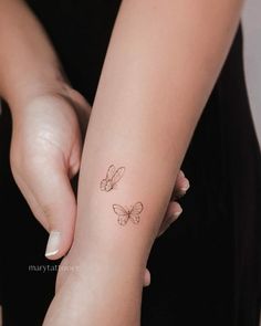 Tiny Two Butterfly Tattoo on Wrist Two Butterfly Tattoo, Butterfly Tattoo Wrist, Butterfly Tattoo On Wrist, Tattoo Butterflies, From Caterpillar To Butterfly, Nana Tattoo, Minimalist Tattoo Design, Caterpillar To Butterfly, Tiny Butterfly Tattoo