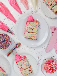 several pieces of cake on plates with sprinkles and pink icing next to them