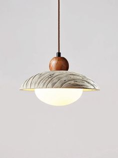 a light hanging from a ceiling fixture with a wooden ball on it's end