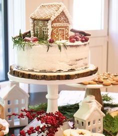 a white cake sitting on top of a table covered in cookies and other food items