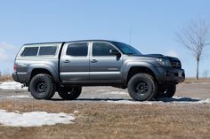 a silver truck parked on top of a snow covered field