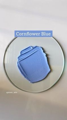 a white plate topped with a blue cake covered in frosting next to the words cornflower blue