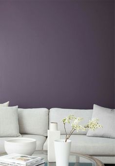 a living room with purple walls and white furniture