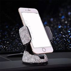 a cell phone in a holder on top of a car dashboard with glitters behind it