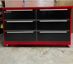 a red and black tool cabinet with tools on it