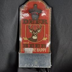 a red and white sign with a deer head on it's side, hanging from a wall