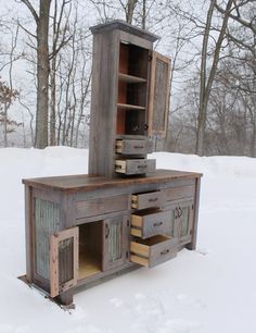 an old wooden cabinet sitting in the snow