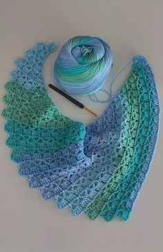 a crocheted shawl with yarn next to it