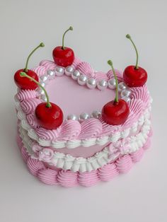 a cake decorated with cherries and pearls