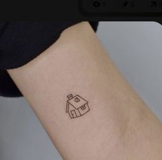 a small house tattoo on the right inner arm and wrist, which has a line drawn across it