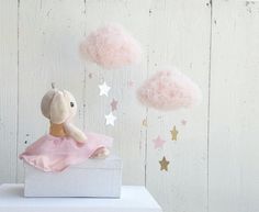 a stuffed animal in a pink dress sitting on top of a white box next to stars