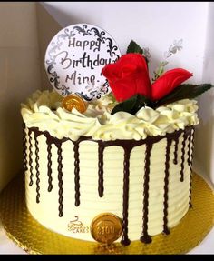 a birthday cake with white frosting and chocolate drips