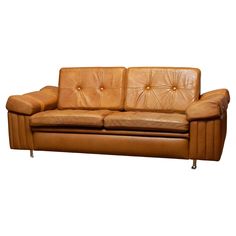 a brown leather couch sitting on top of a white floor