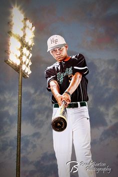 a man holding a baseball bat next to a light pole