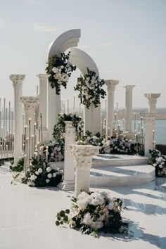 an outdoor wedding setup with white flowers and greenery on the steps leading up to it