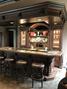 an elegant home bar with stools around it