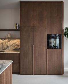 a kitchen with wooden cabinets and marble counter tops