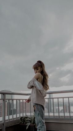 a young woman standing on top of a roof