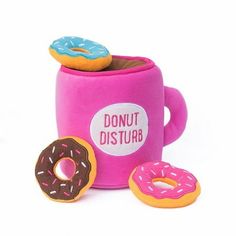 two donuts are sitting on top of a pink coffee cup with the words donut disturb