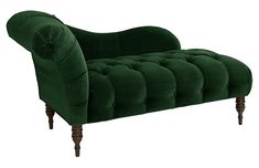 a green velvet chaise lounge chair with wooden legs and turned back, on an isolated white background