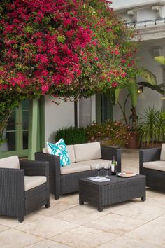 an outdoor living area with furniture and flowers