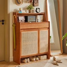 a wooden cabinet sitting next to a mirror on top of a hard wood floor in front of a doorway