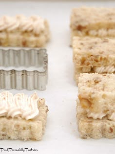 four pieces of cake sitting on top of a white counter next to one piece of frosting