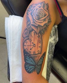 a woman with a tattoo on her arm has a clock and a rose in it