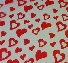 many red hearts are arranged on a white surface