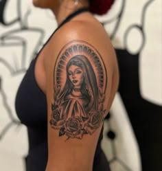 a woman's arm with a tattoo on it and an image of the virgin mary