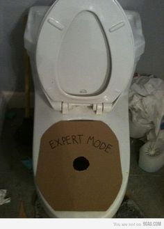 a white toilet with the lid up and an exert mode sticker on it