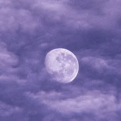 the full moon is seen through some clouds