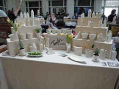 a table topped with lots of white vases