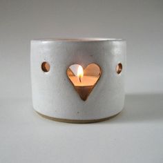 a white candle holder with a heart on it