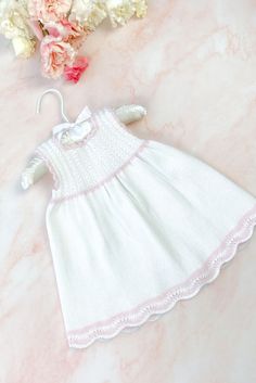 A beautiful, and easy to knit, baby summer dress. White Fitted Crochet Dress In Cute Style, White Fitted Crochet Dress, Cute Style, White Fitted Crochet Dress Cute Style, White Fitted Crochet Dress, Cute White Crochet Summer Dress, White Sleeveless Knitted Dress, Cute Hand Knitted Pink Dress, Cute Pink Knitted Dress, Hand Knitted Cute Spring Dresses