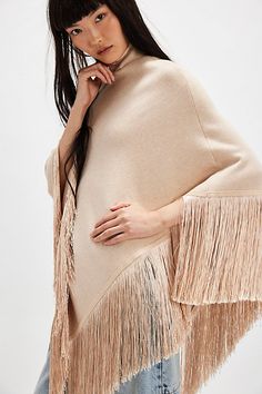 Forever cool and classic, this stand-out poncho is featured in a staple silhouette with turtle neckline and fringe-adorned bottom trim to add the loveliest layer to absolutely every look. | River Walk Poncho Jacket by Understated Leather at Free People in Tan, Size: M/L Fringed Long Sleeve Poncho For Fall, Long Sleeve Fringe Poncho For Fall, Fringe Long Sleeve Poncho For Fall, Winter Fringe Cape Outerwear, Winter Cape With Tassels, Oversized Fringe Cape For Fall, Fall Fringe Cape Outerwear, Fringe Cape Outerwear For Fall, Oversized Fringe Cape For Winter