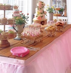 a table topped with lots of cakes and desserts next to a birdcage