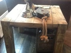 a wooden table with a telephone on top and rope hanging from it's end